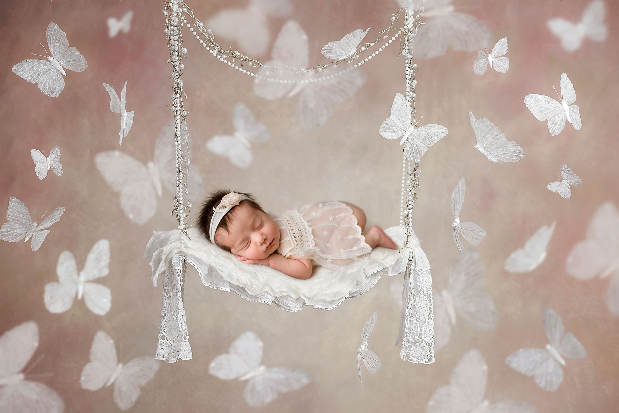 NJ newborn photographer capturing baby girl sleeping on a white swing