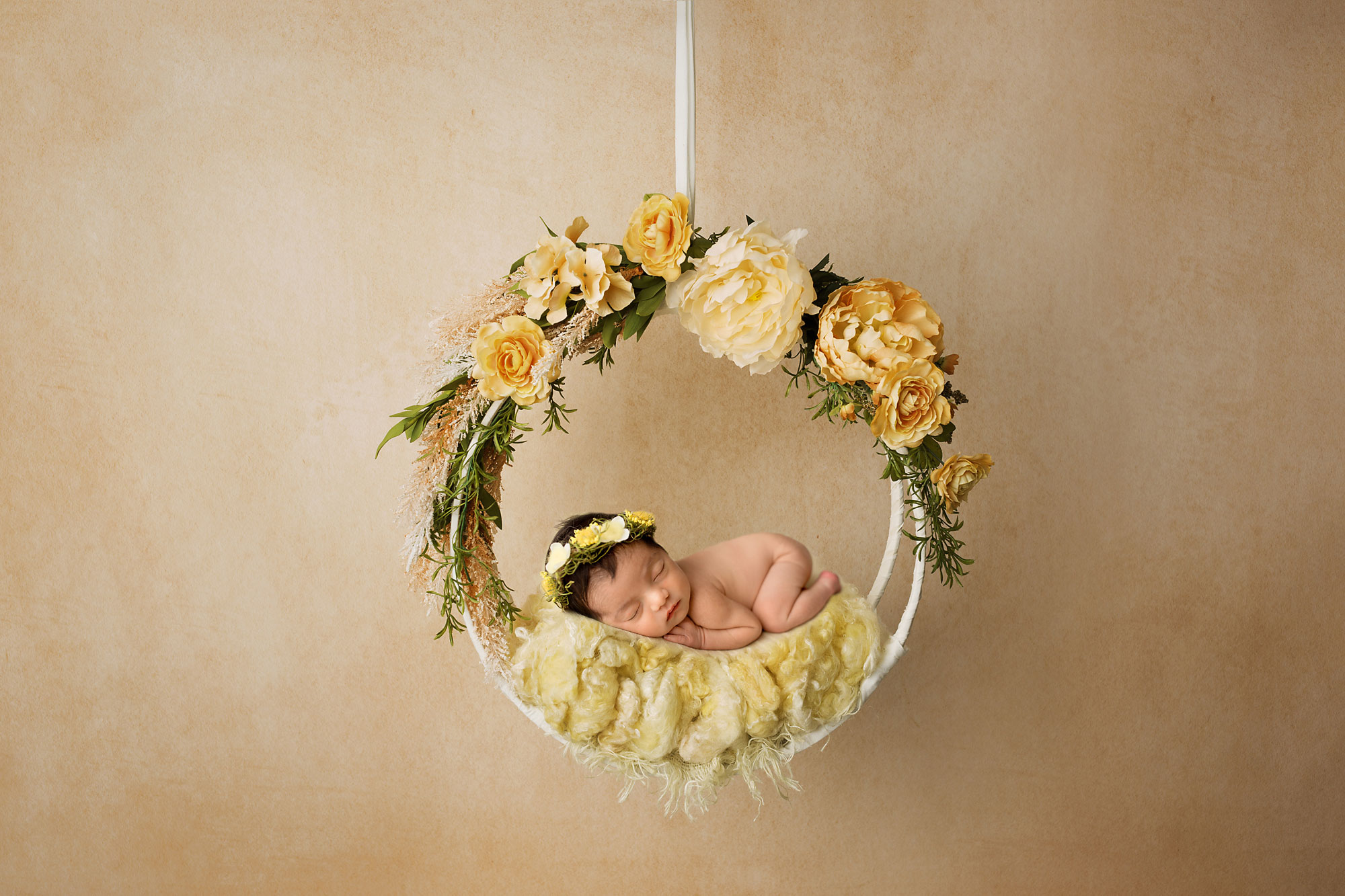 baby sleeping in a yellow floral wreath